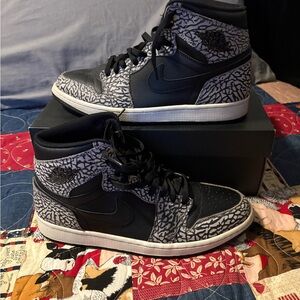 Air Jordan 1 Retro High sneaker featuring a black upper with an elephant print.